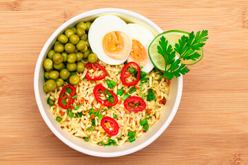 Beautiful Noodle Dish with Green Pea, Eggs, Red Hot Pepper and Greens on Bamboo Cutting Board. Instant Noodles with Vegetables
