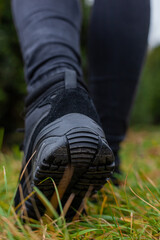 Black sneakers on the legs in black jeans at the girl on the street