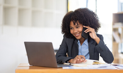 Cheerful business african american girl woman speaking on the phone in a workplace.