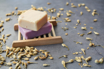 Homemade natural soap bar and dry flower on black background 