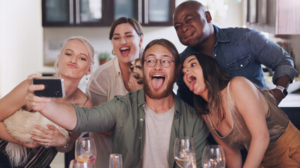 Obraz premium Friends, selfie and silly pose during dinner party at home to celebrate new years eve together. Phone, photo and funny face diverse group of people posing for a mobile picture during lunch
