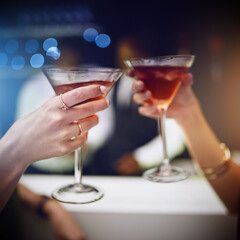 Hands, cocktail and party with friends drinking together in a nightclub for a new year celebration. Glass, toast and event with a female and friend celebrating with a cheers in a music club or disco