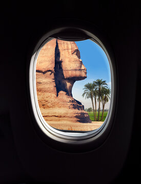 Landscape with Egyptian sphinx and palm trees in a frame of aircraft porthole window. Travel concept for airline company or touristic transportation to Egypt.