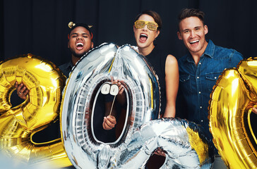 New year, happy and friends portrait with balloons at a social celebration in a event photobooth....