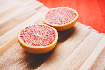 Colorful background in coral and red with fresh open grapefruit