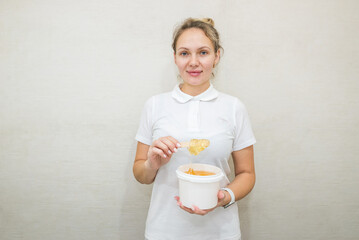 portrait of a woman with a jar of sugar paste for sugaring