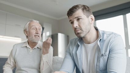 Elderly father shouting at son, conflict between generations, misunderstanding