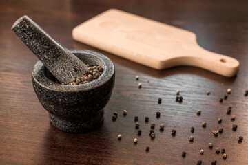 Peppercorns with granite mortar. Pepper spice 