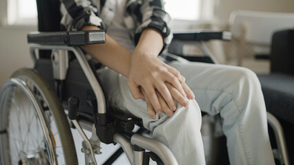 Obraz premium Boy feeling pain in knees, sitting in wheelchair, rehabilitation after injury