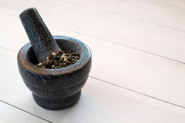 Peppercorns with granite mortar. Pepper spice 