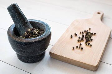 Peppercorns with granite mortar. Pepper spice 