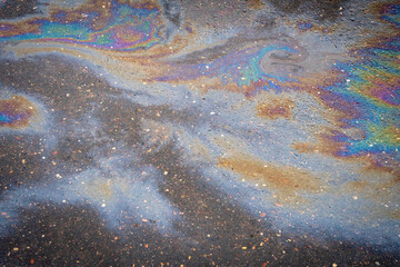 Image of an oil stain on the asphalt of a wet road.