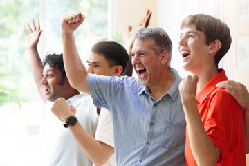 Group of football fans watch tv at home.