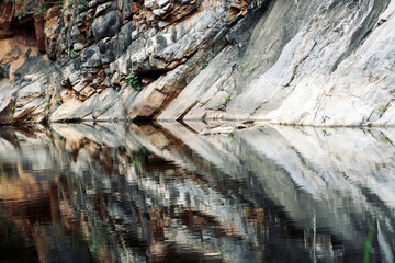 Rocks and reflections in T.P Kota waterfalls at Andhra Pradesh, India. Mountain reflection in still water.