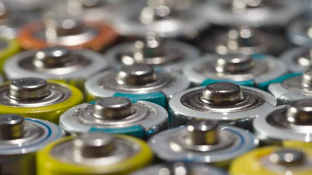 Old Battery Conveyor. Loop. Dense array of AA batteries moving with slight rotation close-up