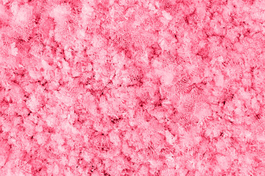 Abstract texture pink red Winter background with snow patterns, crystals close-up and snowflakes toned viva magenta color of the year 2023 Natural snow frosty background with copy space