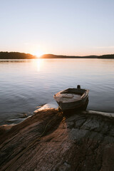 A boat at the rocky island on a lake in northern Europe at sunset