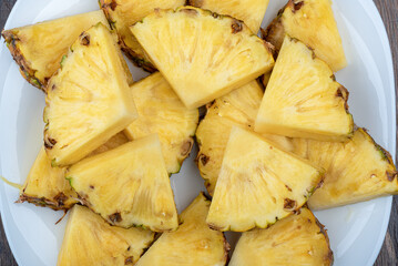Top view of pineapple slices on a white plate.