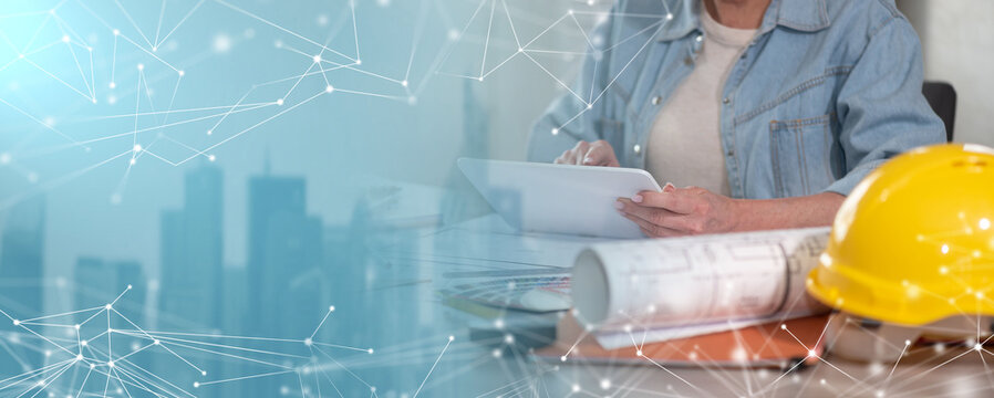 Female architect working on construction project with digital tablet; panoramic banner