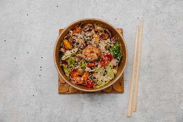 Seafood salad in a craft plate on a gray background. View from above.
