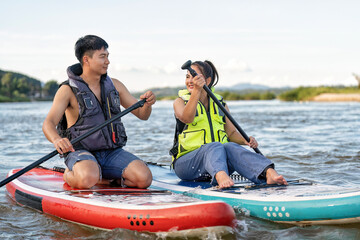 On summer holiday love couple relax sail sup board surf on river on beautiful nature calm river