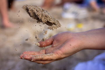 hand playing with sand