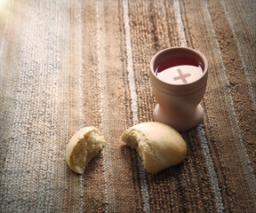 A bowl of wine and bread on the table. Communion symbols