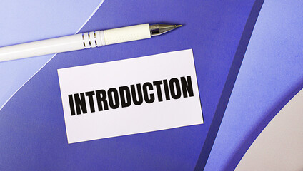 On a lilac and purple background, a white card with the text INTRODUCTION and a white pen. Layered background.