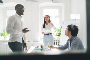 Group of diverse colleagues discussing project with manager in office