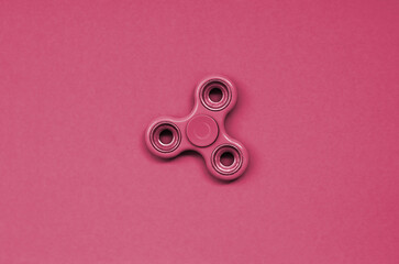 Green fidget spinner lies on texture background of fashion pastel green paper in minimal concept....