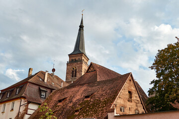 Fototapeta na wymiar Kirchturm über alten Dächern