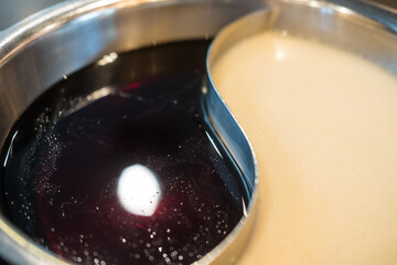 Two ways soup, clear soup and black soup base on stainless steel pot. Shabu Shabu or Sukiyaki