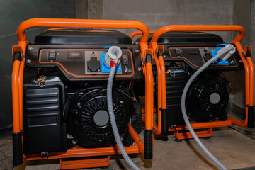 Fototapeta premium Two gasoline generators generate electricity during the blackout. Powerful electric generators work in the garage.