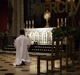 curé en train de prier devant l'autel d'une église - obrazy, fototapety, plakaty