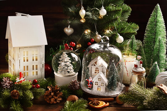Christmas decoration with white house shaped decors under the glass cloche  and lantern on the table