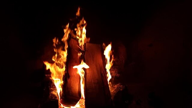 Worm cosy burning fire with beautiful flames in the fireplace. Burning woods. Preparing dinner. Slow motion. Dark background. High quality 4k footage