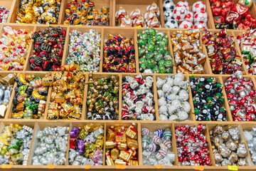 Fototapeta na wymiar Glass toys for the festive decoration of the Christmas tree on the counter of the street bazaar on the eve of Christmas and New Year. Sales and purchases of toy decorations in December