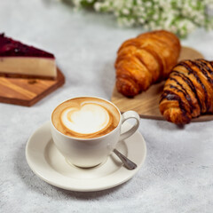 Coffee and croissant on white table. French breakfast.