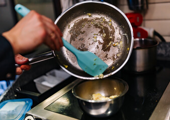 man chef cooking tasty scrambled eggs in frying pan on kitchen