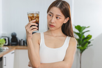 woman holding a glass of soft drink and worrying about sugar diet