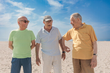 tre anziani amici al mare con abiti colorati si divertono e chicchierano