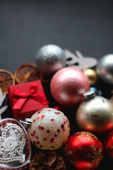 Various colorful Christmas ornaments on dark background, selective focus.