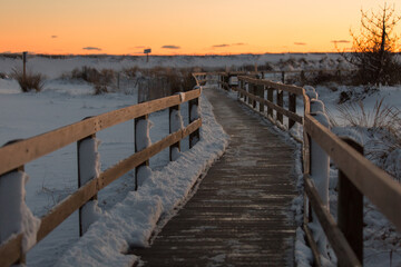 A beach boardwalk at Robert Moses State Park, Fire Island, Long Island New York, covered in snow after a winter blizzard