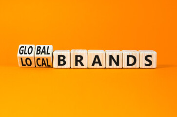 Global or local brands symbol. Concept words Global brands and Local brands on wooden cubes. Beautiful orange table orange background. Business global or local brand concept. Copy space.