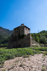 View of the Baells Reservoir and the mountains around it during dry season. Dry dam with small river passing trough. Monestery of Sant Salvador de la Vedella in the middle