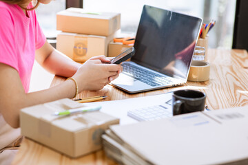 Fototapeta premium start a small business Young Asian small business owner working as a freelancer and packing boxes for deliveries to customers. order online