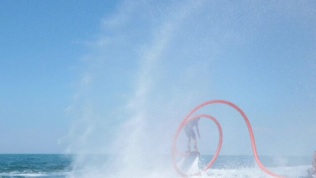 Water extreme sport. The guy is flying at the aquatic flyboard. A lot of water pressure.