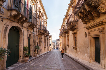 Female tourist walking between ancient buildings