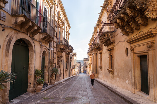 Female tourist walking between ancient buildings