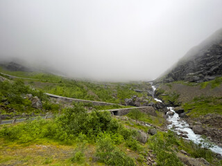 fog over the mountain with a river and old road